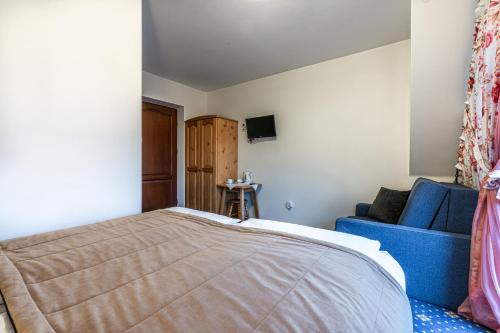 a bedroom with a bed and a blue couch at Dunajecki Dworek in Zakopane
