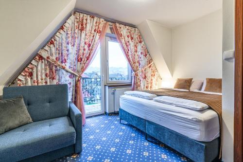 a bedroom with a bed and a couch and a window at Dunajecki Dworek in Zakopane