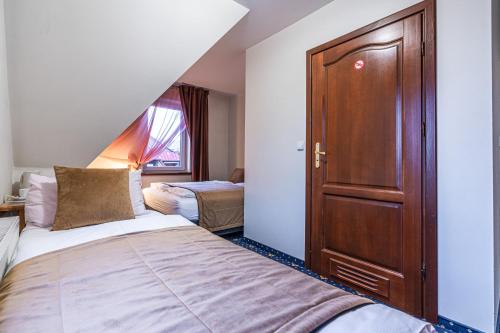 a bedroom with a bed and a wooden door at Dunajecki Dworek in Zakopane