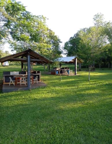 a picnic shelter in a park with green grass at Los Lapachos Lodge in Puerto Libertad