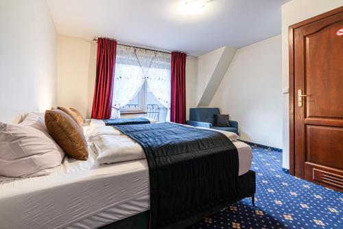 a hotel room with a bed and a window at Dunajecki Dworek in Zakopane