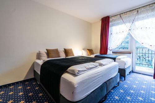 a bedroom with two beds and a window at Dunajecki Dworek in Zakopane