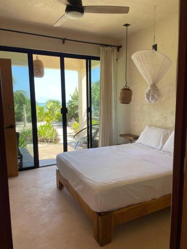 a bedroom with a bed and a view of the ocean at Villa Queridoro Mahahual in Mahahual