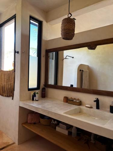 a bathroom with a sink and a mirror at Villa Queridoro Mahahual in Mahahual