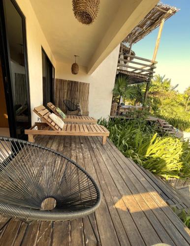 a wooden deck with a bench on a house at Villa Queridoro Mahahual in Mahahual
