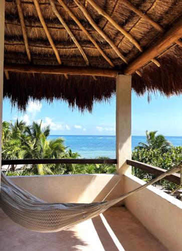 a hammock on a resort balcony with the ocean at Villa Queridoro Mahahual in Mahahual