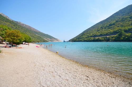 ein Strand mit Menschen, die im Wasser schwimmen in der Unterkunft Apartments Plomin in Plomin