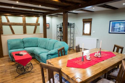 ein Wohnzimmer mit einem blauen Sofa und einem Holztisch in der Unterkunft la petite maison in Wintzenheim