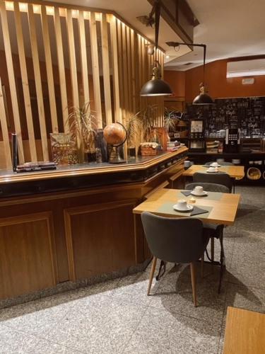 Hotel Lusitano في فيلار فورموسو: مطعم مع كونتر وطاولة وكراسي