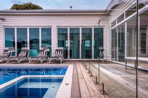 a home with a swimming pool and a house at Ocean Beach House Sorrento - Luxury with Heated Pool and Spa in Sorrento