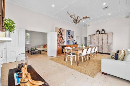a kitchen and living room with a table and chairs at Ocean Beach House Sorrento - Luxury with Heated Pool and Spa in Sorrento