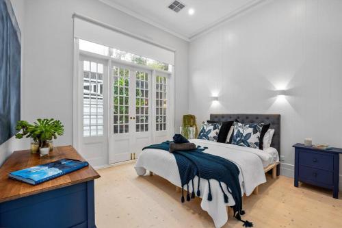 a white bedroom with a bed and a window at Ocean Beach House Sorrento - Luxury with Heated Pool and Spa in Sorrento