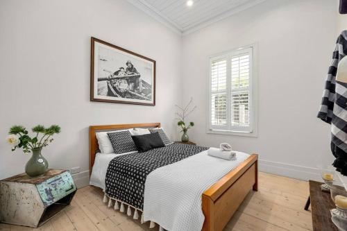 a white bedroom with a bed and a window at Ocean Beach House Sorrento - Luxury with Heated Pool and Spa in Sorrento