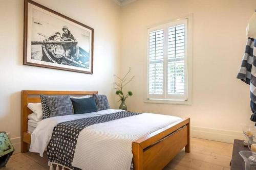 a bedroom with a bed and a picture on the wall at Ocean Beach House Sorrento - Luxury with Heated Pool and Spa in Sorrento