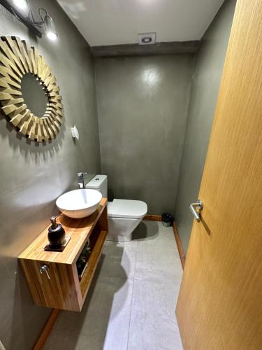 a bathroom with a sink and a toilet and a mirror at Umain 18 SOL in San Martín de los Andes