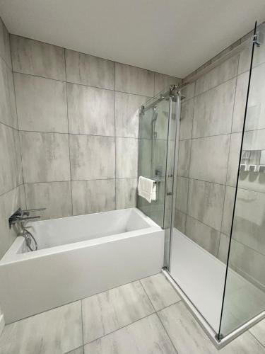 a bathroom with a tub and a glass shower at Le 800 de St-Jovite in Mont-Tremblant