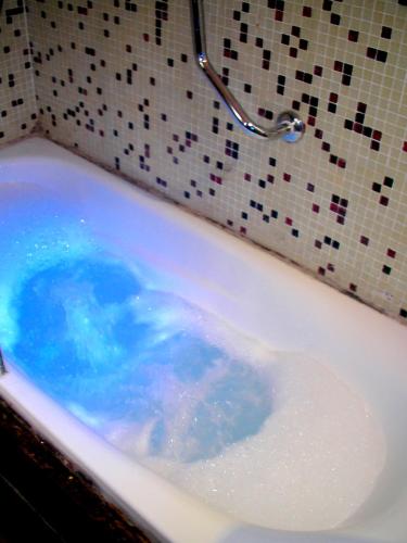 a bath tub filled with lots of blue water at Altos Medanos Cabañas & Club de Bosque in Mar de las Pampas