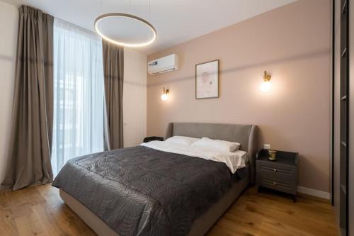a bedroom with a bed and a large window at Orange Luxury King bed Apartment, bussiness, leisure in One Cotroceni in Bucharest