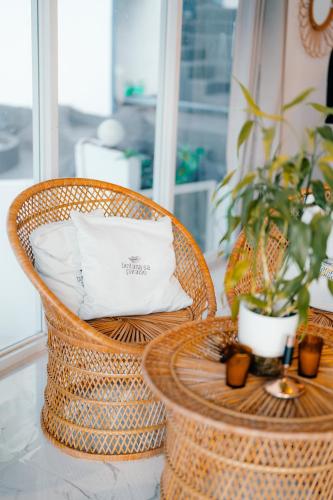 a wicker chair with a pillow and a table at Bintana Sa Paraiso in Mambajao
