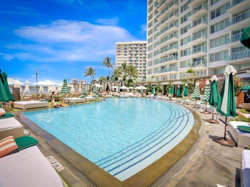 a large swimming pool next to a large building at 1100 West South Beach Luxe Miami Condos by Joe Semary in Miami Beach