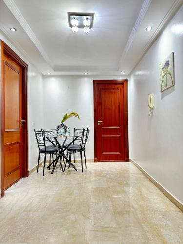 a dining room with a table and a red door at SUITOUISS - Agdal 3 - Appartement à 2 minutes de la gare de train TGV Rabat in Rabat