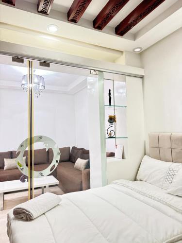 a bedroom with a bed and a living room at SUITOUISS - Agdal 3 - Appartement à 2 minutes de la gare de train TGV Rabat in Rabat