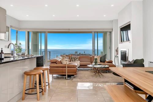 a kitchen and living room with a view of the ocean at Henley's Treasure - Experience Opulence on the Ocean in Henley Beach