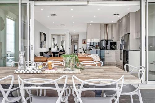 a kitchen and living room with a table and chairs at Henley's Treasure - Experience Opulence on the Ocean in Henley Beach