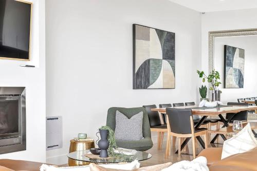 a living room with a table and chairs and a dining room at Henley's Treasure - Experience Opulence on the Ocean in Henley Beach