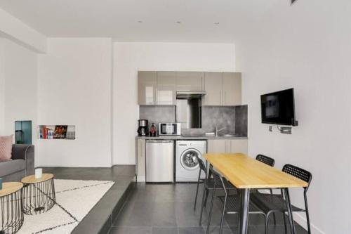 - une cuisine avec une table, une table et des chaises dans l'établissement Appartement cosy près du Marais, à Paris