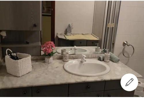 Cuenta con una encimera con lavabo y un espejo grande. en Secuoya, en Cabezón de la Sal