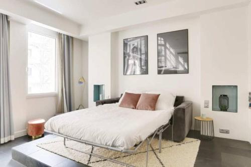 - une chambre blanche avec un lit et un canapé dans l'établissement Appartement cosy près du Marais, à Paris