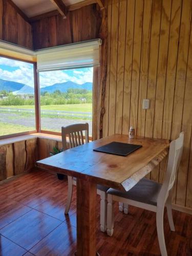 a wooden table in a room with a laptop on it at Cabaña Antü küyen Melipeuco in Melipeuco