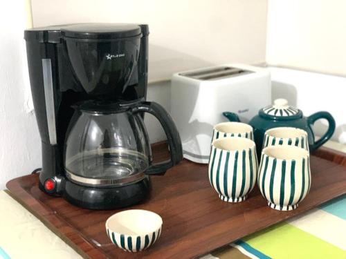 eine Kaffeemaschine auf einem Holzregal mit drei Tassen in der Unterkunft LaMaison Ayem Zmen S3 in El Haouach