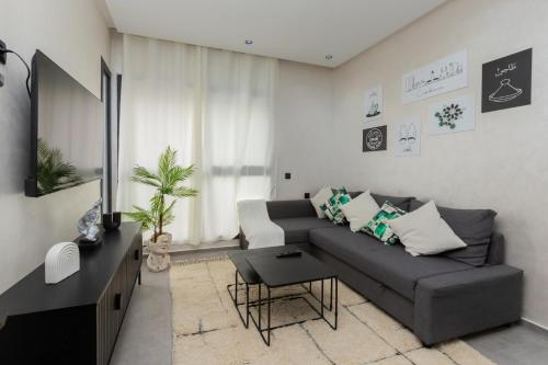 a living room with a couch and a table at Appartement cosy et moderne Bouskoura proche Aéroport et Hopital universitaire in Bouskoura