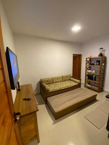 a bedroom with a bed and a tv and a table at Village Martin de Sá in Caraguatatuba