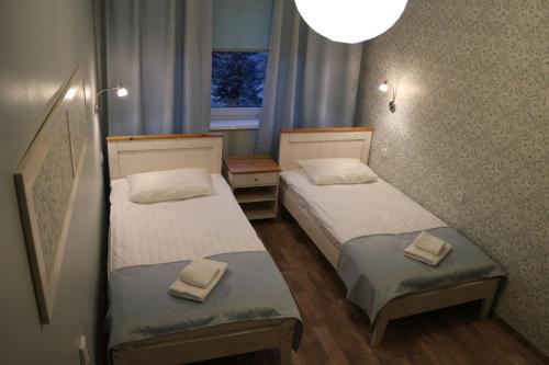 two beds in a small room with a window at Uma Kuup Guest Apartments in Võru