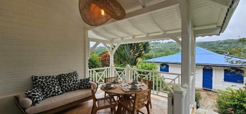 a porch with a couch and a table at Villa M'Bay in Sainte-Marie