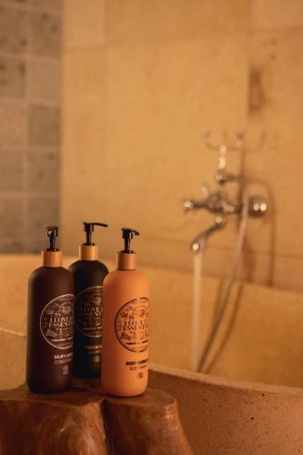 three shampoo bottles sitting on a counter in a bathroom at Oslo Guldsmeden in Oslo