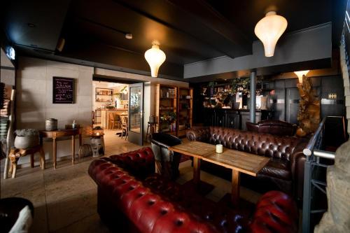 a bar with leather couches and a table in a room at Oslo Guldsmeden in Oslo