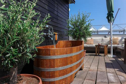 a wooden barrel tub sitting on a patio with plants at Babette Guldsmeden in Copenhagen