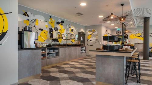a kitchen with a counter with yellow shoes on the wall at Holiday Inn - the niu, Fury Aschheim Messe by IHG in Aschheim