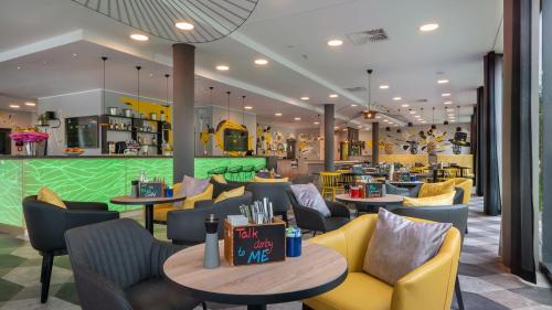 a restaurant with couches and tables and chairs at Holiday Inn - the niu, Fury Aschheim Messe by IHG in Aschheim