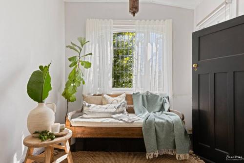 a bedroom with a bed with a window and a chair at The Waratah House -Indoor Sauna & Outdoor Firepit and walking distance to Town center in Katoomba