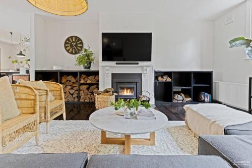 a living room with a table and a fireplace at The Waratah House -Indoor Sauna & Outdoor Firepit and walking distance to Town center in Katoomba