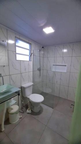 a bathroom with a toilet and a shower and a sink at Casa a beira-mar in Santa Vitória do Palmar