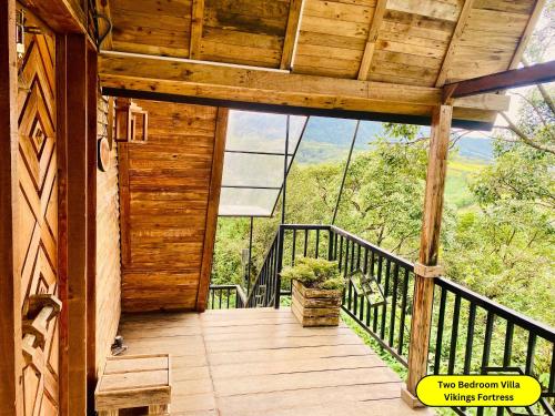 a porch of a cabin with a view of the mountains at Hunters Wood Cabins in Nuwara Eliya