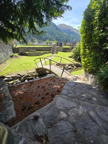 a stone walkway leading to a park with a mountain at The Last Resort Hostel in Queenstown