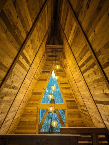 a room with a wooden ceiling with a window at Hunters Wood Cabins in Nuwara Eliya
