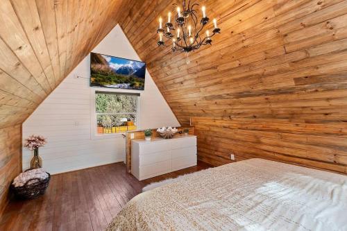 ein Schlafzimmer mit einer Holzwand mit einem Bett und einem Fenster in der Unterkunft NEW Cozy Coy Cabin with Hot Tub & AC in Big Bear City